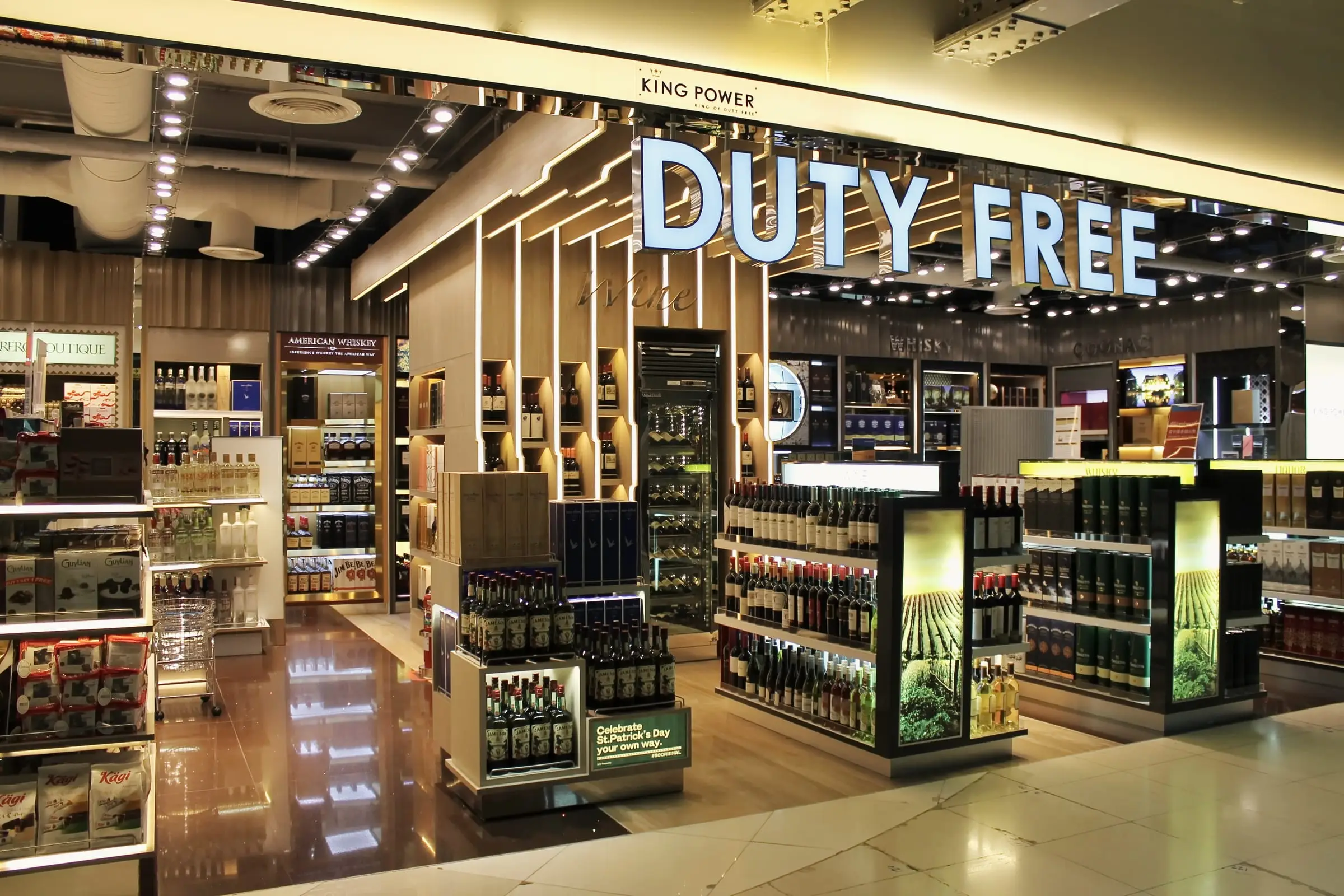 Winkelvloer van een duty-free-zaak met verlichte belettering en gevulde schappen